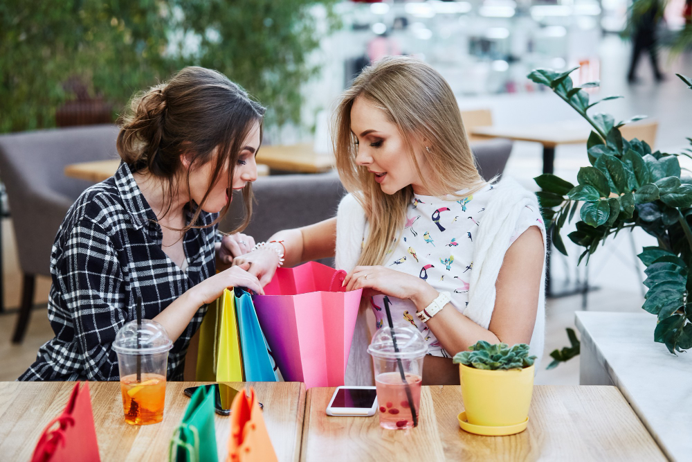 Ein Bild von zwei Frauen, die sich über Einkaufstüten beugen
