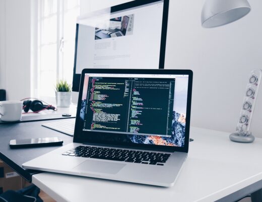 Modernes Büro mit Laptop und Code auf dem Bildschirm – Team bereitet Prozesse für E-Rechnung Pflicht 2025 (XRechnung/ZUGFeRD) vor.