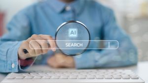 KI-Suche 2025 – Hand mit Lupe über Suchleiste „Search“ samt AI-Icon, vor Tastatur; Symbol für generative Suche und datengetriebene Webrecherche.