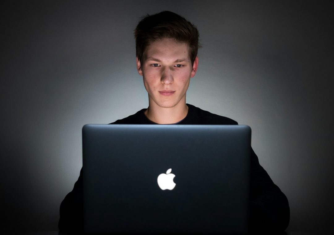 Junger Softwareentwickler arbeitet an einem Laptop und entwickelt Anwendungen mit Künstlicher Intelligenz.