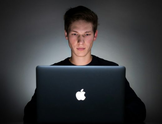 Junger Softwareentwickler arbeitet an einem Laptop und entwickelt Anwendungen mit Künstlicher Intelligenz.